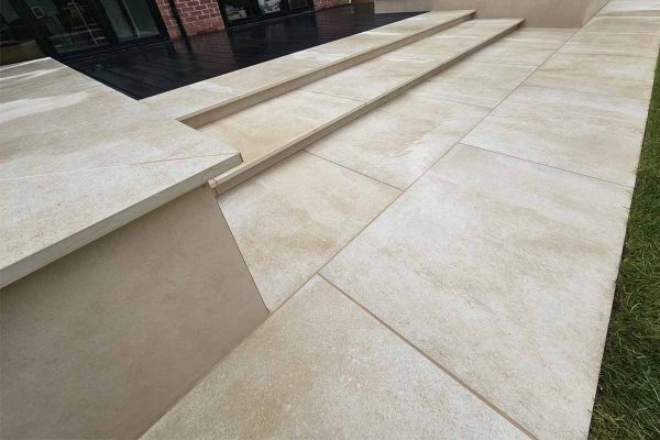 Almeria Beige Compact DesignClad used with very similar porcelain paving slabs, to clad rendered wall with steps leading to house.***JLM Garden Design, www.jlmgardendesign.co.uk