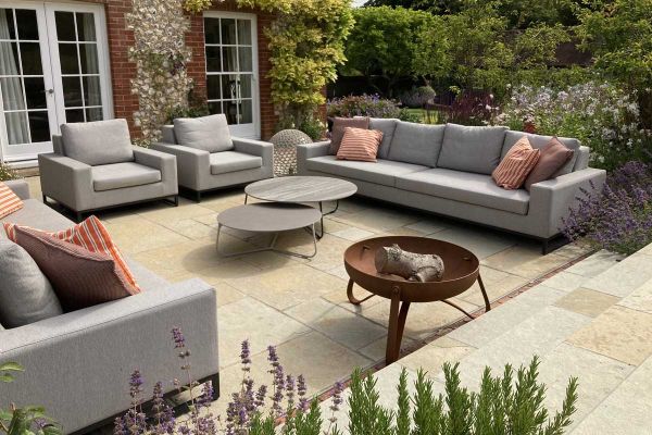 Modern lounge set sits on Antique Yellow tumbled limestone paving. Design by Bo Cook, built by Simon Scott Landscaping.***Designed by Bo Cook Landscape & Garden Design, www.bocook.co.uk | Built by Simon Scott Landscaping, www.simonscottlandscaping.co.uk