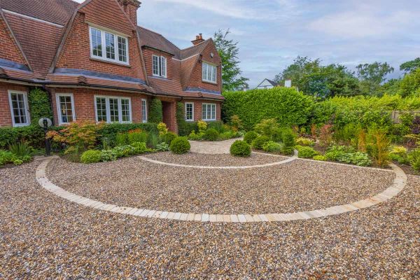 View from front of property shows large area using pebbles with Mint Sandstone cobble setts used to create circular patterns.***Designed by Chiltern Garden Design | Built by Castle Landscapes | Photos by Nigel Proctor Photography
