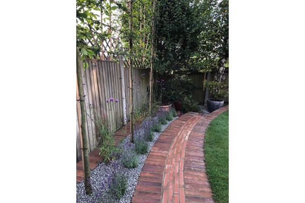 Soldier courses of Bromley Paving Bricks laid flat either side of on-edge pavers in running bond, in path by Outsiders Landscaping.***Outsiders Landscaping Ltd, www.outsiderslandscaping.co.uk
