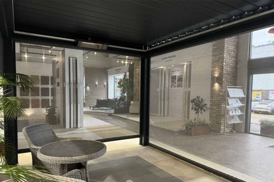 Deluxe Anthracite Grey Metal Pergola displayed in a showroom, with blinds fully extended for shade.