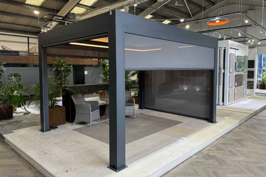 Deluxe Anthracite Grey Metal Pergola with LED lighting installed, creating a warm, inviting atmosphere, installed in showroom.