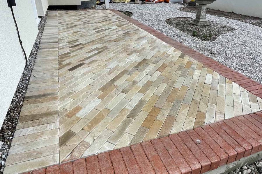 Close up shot of Tumbled Mint Sandstone pavers used as front entrance step, bordered with red pavers.