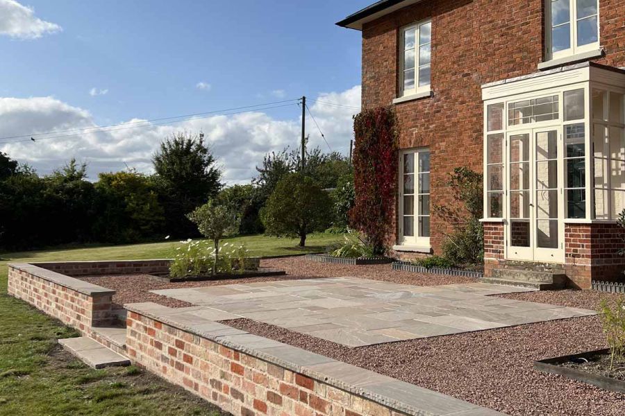 Side view of traditional house using autumn brown indian sandstone paving, bullnose steps and copings.