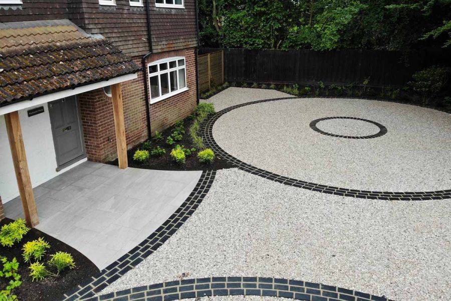 Birds eye view shows midnight black limestone setts creating circles around a grey resin fron driveway.