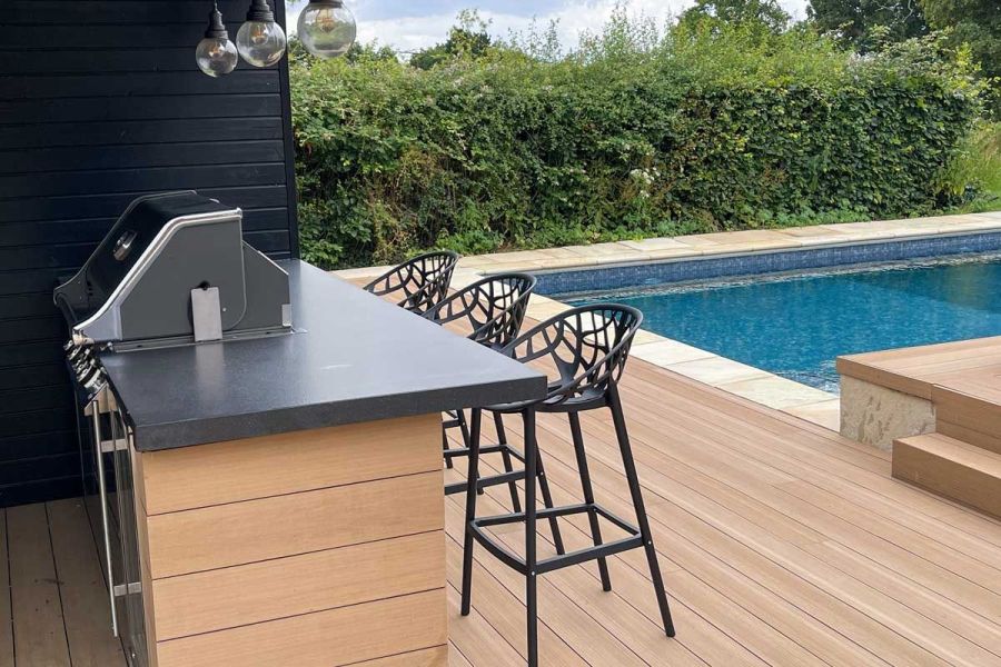 Black bar stools on Cinnamon DesignBoard composite fascia boards by a counter, matching a bench in the background. Design by Marlene Lento.