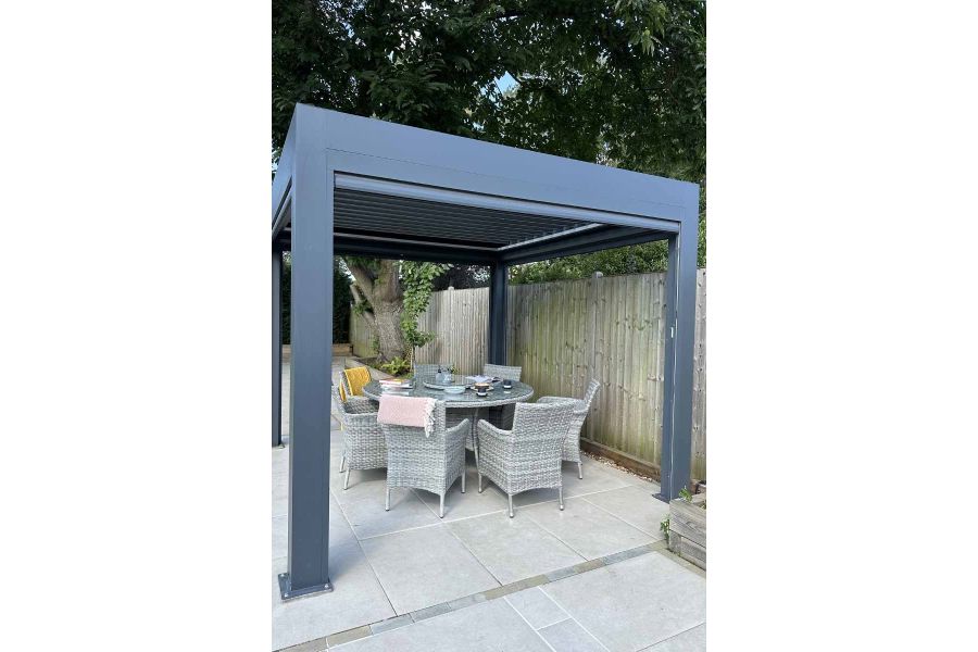 Close-up view of a dining area under the Anthracite Grey 3x3 Deluxe Pergola, highlighting the alfresco dining experience in the shade.