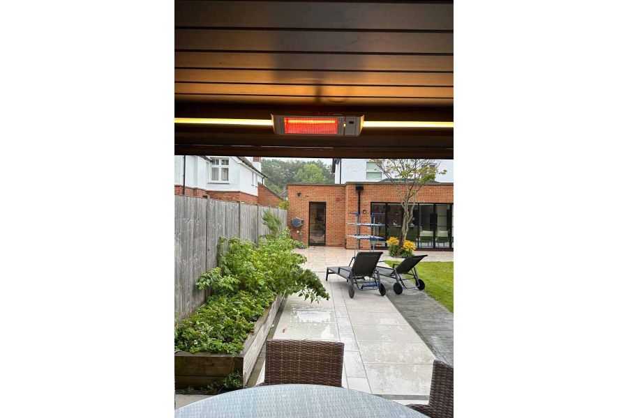 Deluxe Anthracite Grey 3x3 Metal Pergola in a landscaped garden, with heater for year-round comfort.