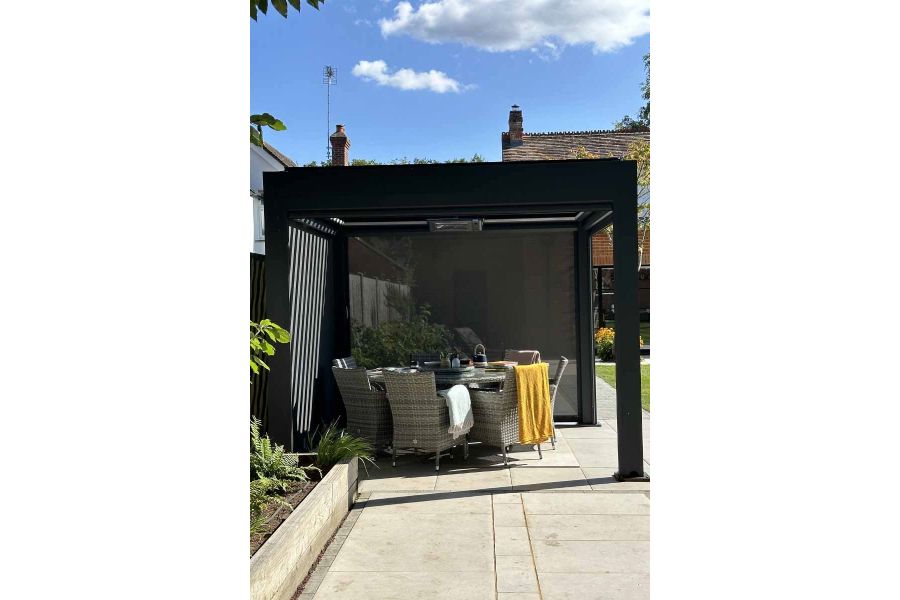 Detailed shot of the Deluxe Anthracite Grey 3x3 Metal Pergola with one side blind down and the louvres open.