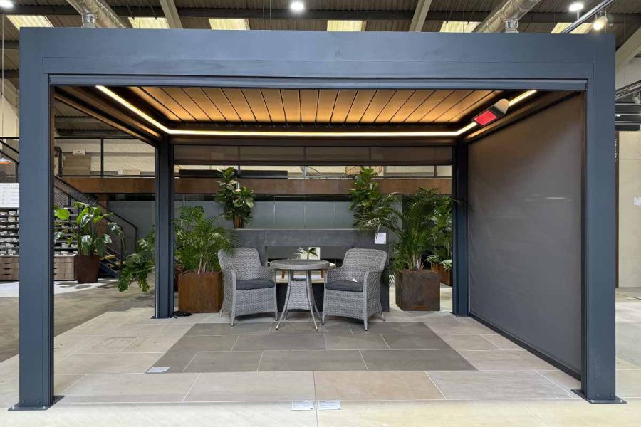 Showroom setting sees Deluxe Metal Pergola with heaters installed, creating a cozy spaces for cooler evenings.