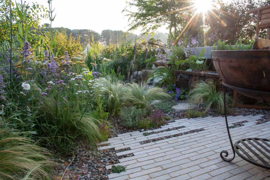 A patio of Egyptian Beige stone pavers bordered by lush greenery, illustrating their ability to complement traditional garden settings.