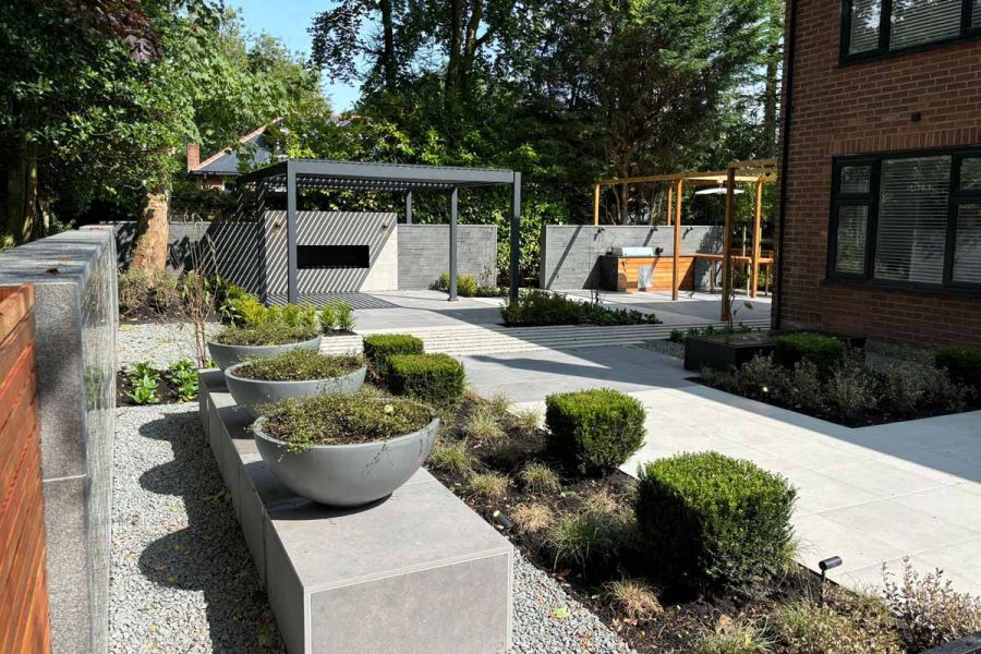 Metal pergola stands at the end of large garden using florence grey porcelain paving mixed with anthracite.