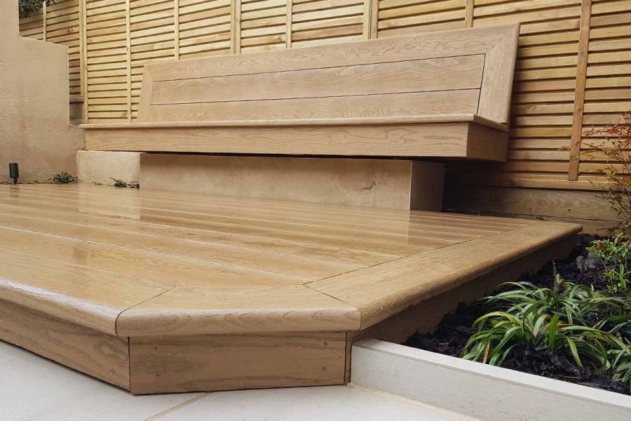 John Gale Landscapes use Golden oak Millboard decking as a semi-floating bench. A deck using boards in the same material beneath.