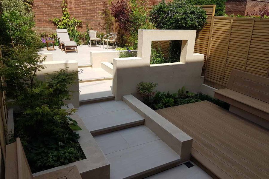 Wide steps created with Faro Porcelain Garden Steps and Paving seen in the shadows, leading up to patio area in the sun.
