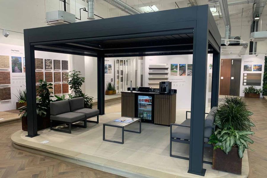 A side view of the Deluxe Anthracite Grey Pergola in a showroom with the blinds extended, offering customers a full view.