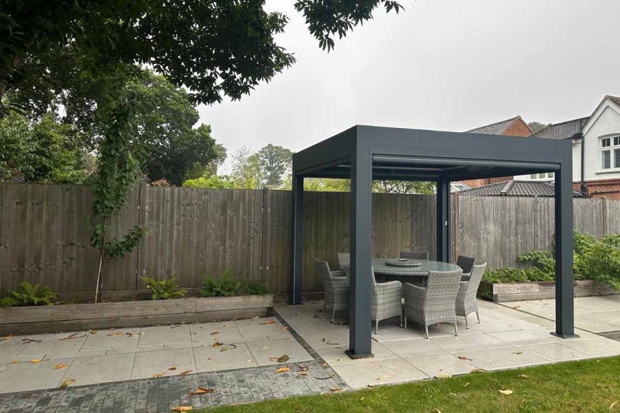 Deluxe Pergola in a spacious backyard, providing a shaded outdoor dining area with its adjustable features.