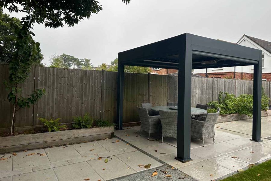 Deluxe Pergola in an open garden setting, providing a private shaded area with its remote-controlled blinds.