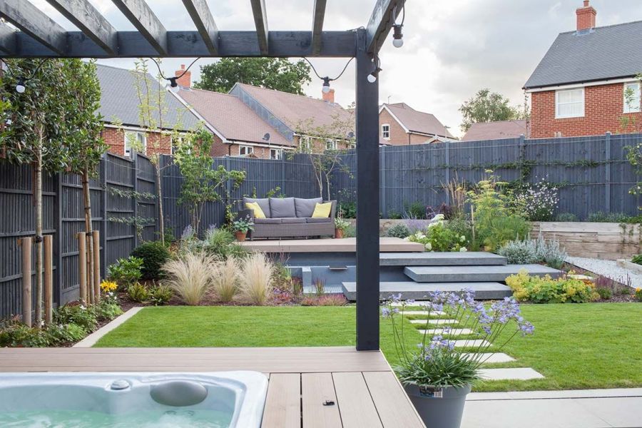 View from hot tub under a pergola showing a multi-level garden with mocha DesignBoard composite fascia boards, creating a unique look.