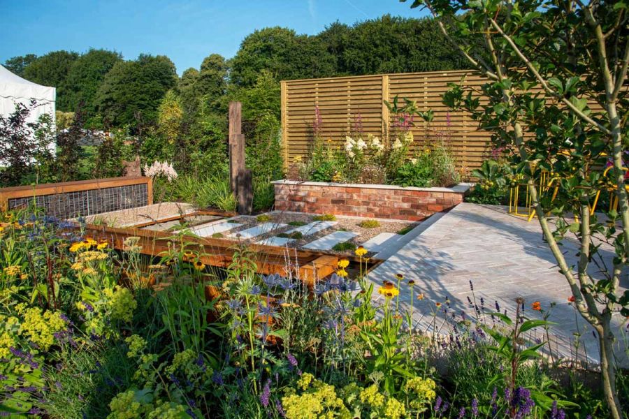 Egyptian Beige stone pavers arranged on a patio, adding texture and interest to a show garden at RHS Chelsea Flower Show Tatton Park.