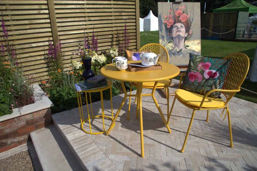 Egyptian Beige stone pavers seamlessly integrated into a show garden design, with matching paving slabs creating a cohesive look.