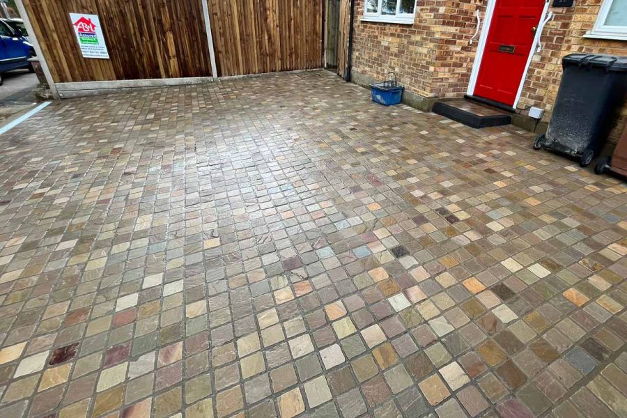 Large driveway uses raj green sandstone cobble setts, shown in wet conditions which shows off vast colour variations.