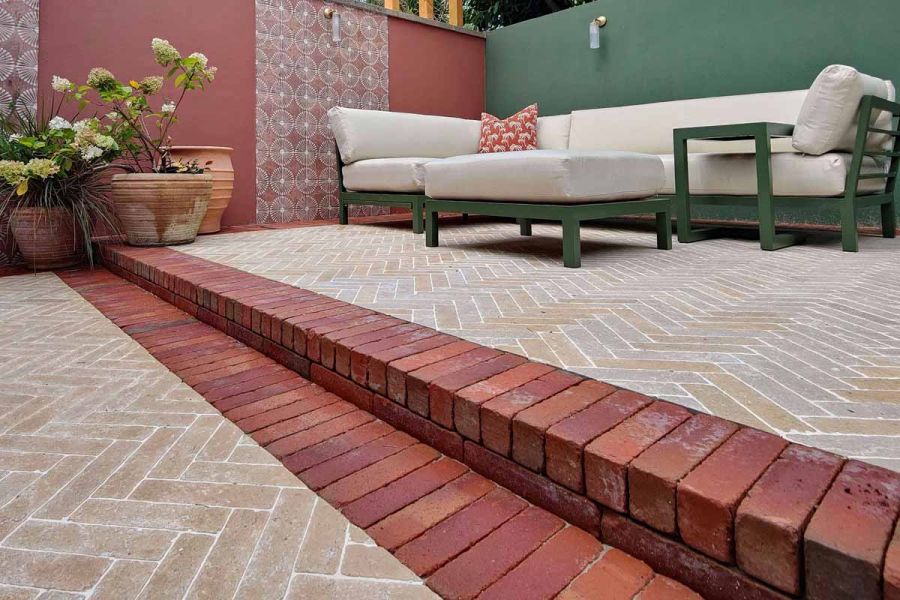 Limestone pavers in herringbone style and seville clay pavers used as border bricks and step up to lounge area.