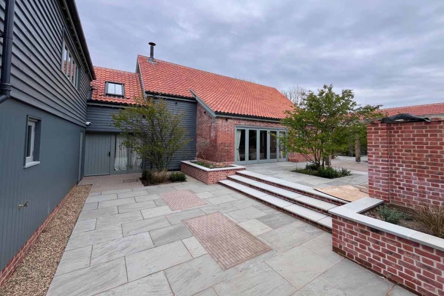Small rectangle patios of Stone Grey Clay Paving laid between grey sandstone paving as unique feature.