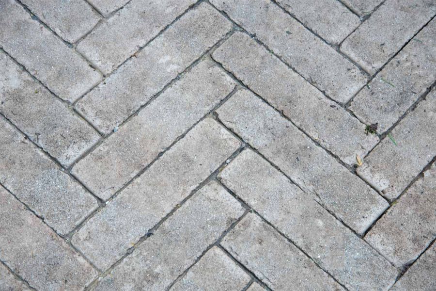 Close-up shot of stone grey clay pavers at RHS Chelsea Flower Show 2024, emphasizing the rustic finish and interlocking pattern.