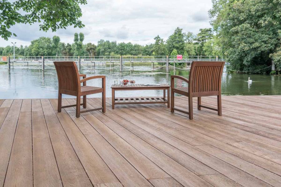 Looking out onto a River with swan floating by, wooden seats and table hosting strawberries on coppered oak millboard.