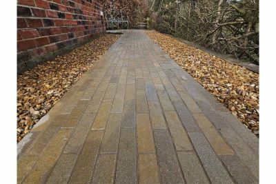 Antique Yellow Stone Pavers used as path down alleyway, the patio bricks have pebbles either side, leading to metal bench.***Vale Landscaping, www.valelandscaping.co.uk

