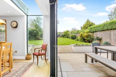 View split between indoors and outdoors through french doors shows antique cream sandstone patio with steaps leading to lawn.***KJC Architects, www.kjcarchitects.co.uk
