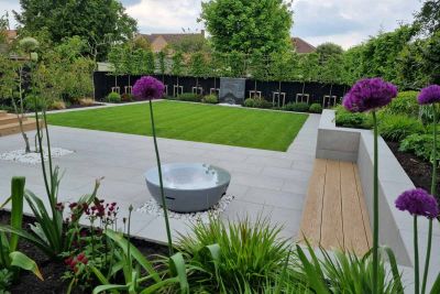 Square lawn sits in the middle of polished concrete porcelain patio with black slate water feature, flowerbeds surround.***Andrew Jordan Landscape & Garden Design
