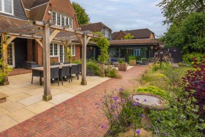 Wooden pergola sits on sandstone patio with seville clay paver path making a break between patio and lawn.***Designed by Chiltern Garden Design | Built by Castle Landscapes | Photos by Nigel Proctor Photography
