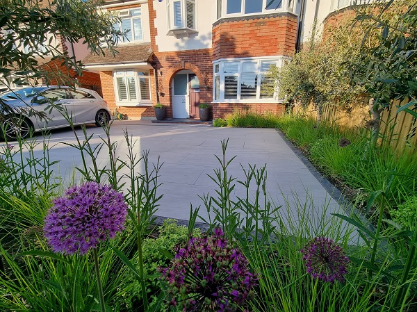 Semi-detached house with large Kandla Grey porcelain driveway, edged with granite setts, and planted borders.