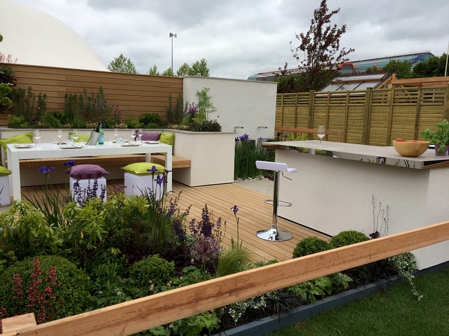 View over railing into Best Lifestyle Garden at BBC GW Live 2015, with outdoor kitchen and decking.