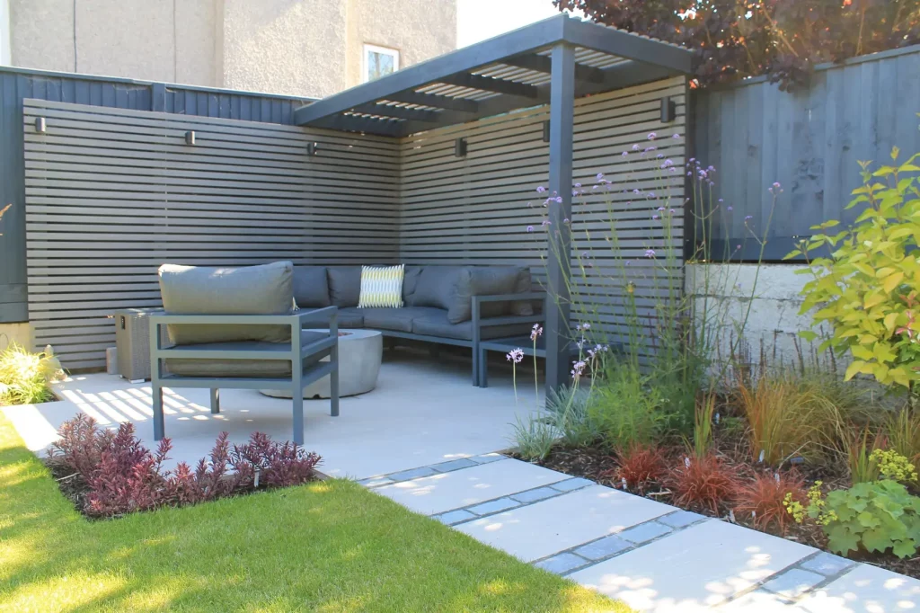 Patio with furniture, and grey composite battens hiding fence behind.