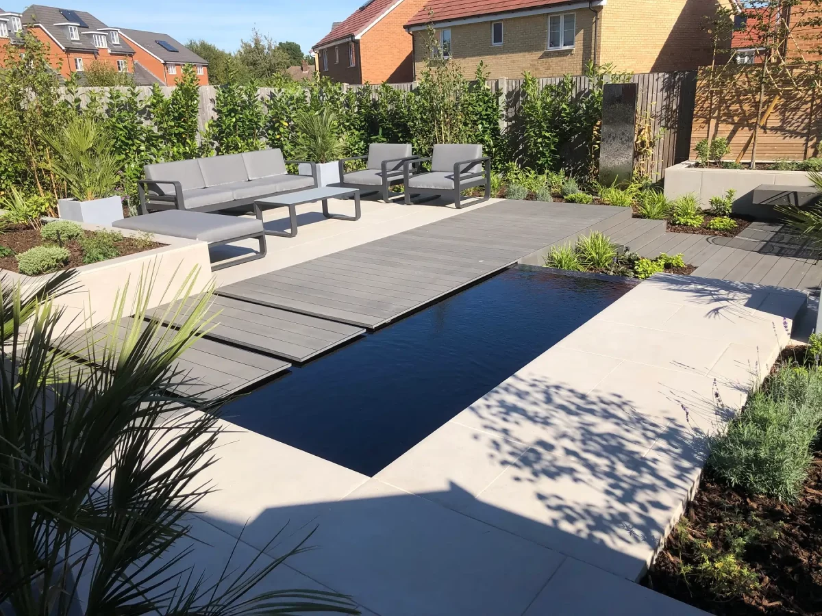 Charcoal DesignBoard creates bridge along long side of rectangular pond, next to Florence Grey porcelain paved seating area.