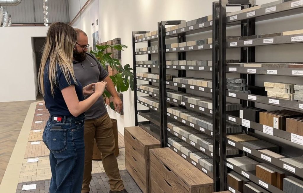 Landscape consultant with customer in front of paving sample display rack